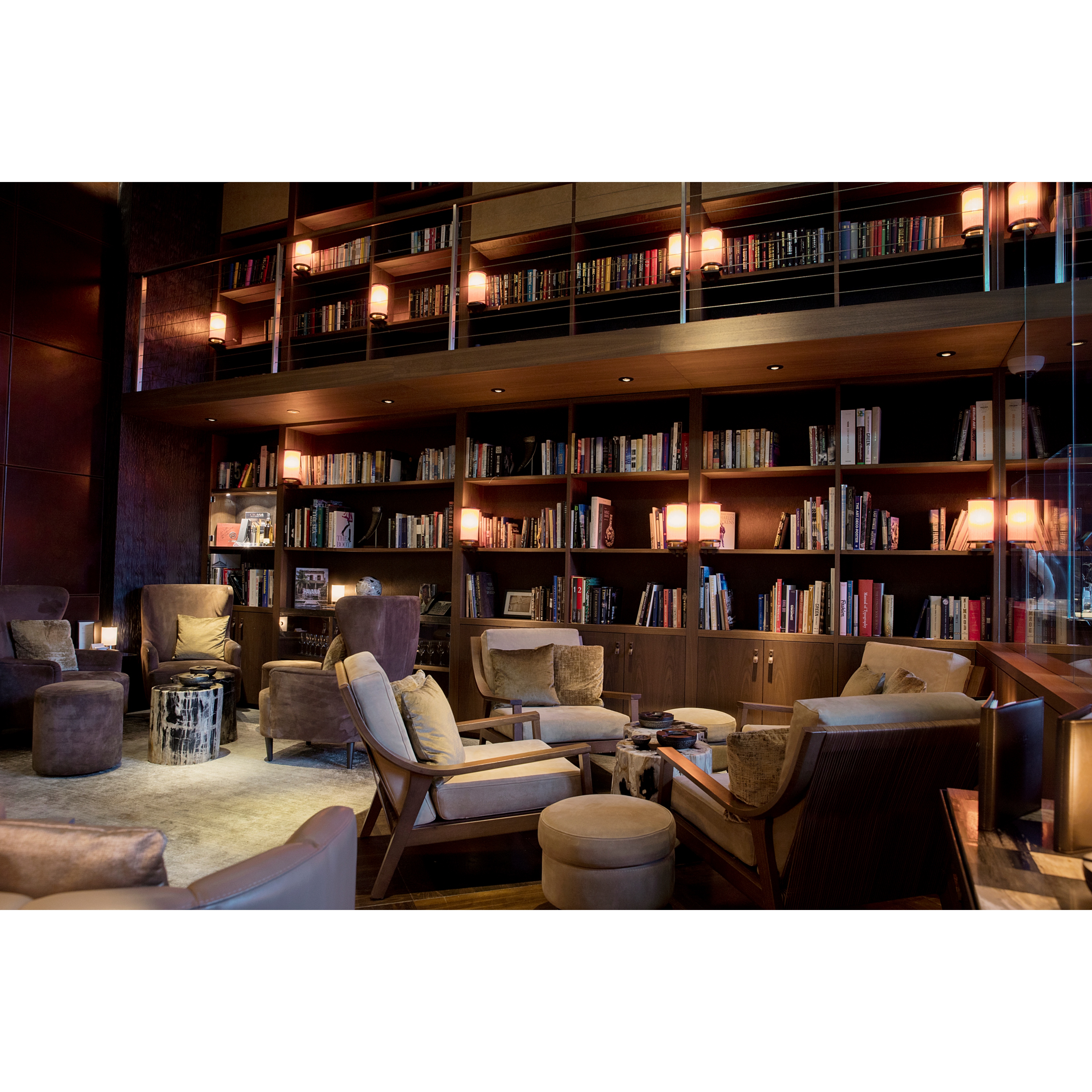 Detail of the cigar library at The Chedi Andermatt. With tall bookshelves in the background and lamps attached to them creating a cozy atmosphere.