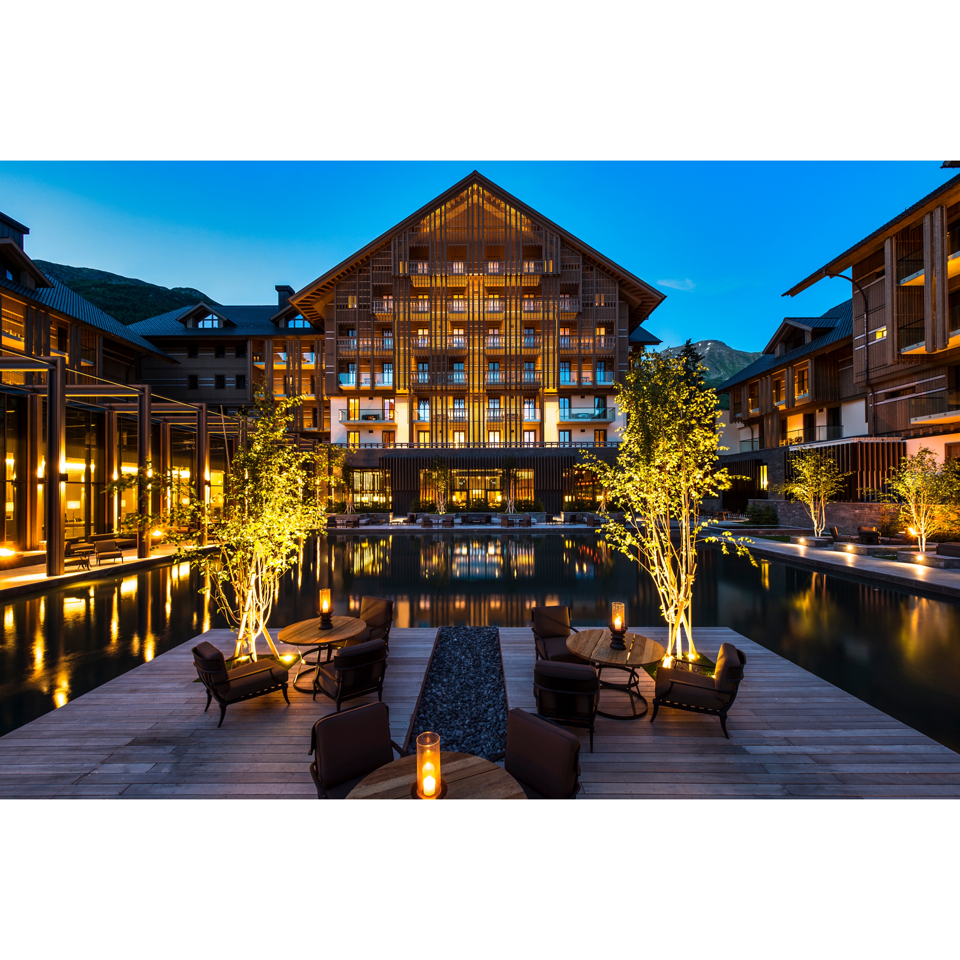 The Chedi Andermatt pool terrace overlooking the main house on a balmy summer evening.