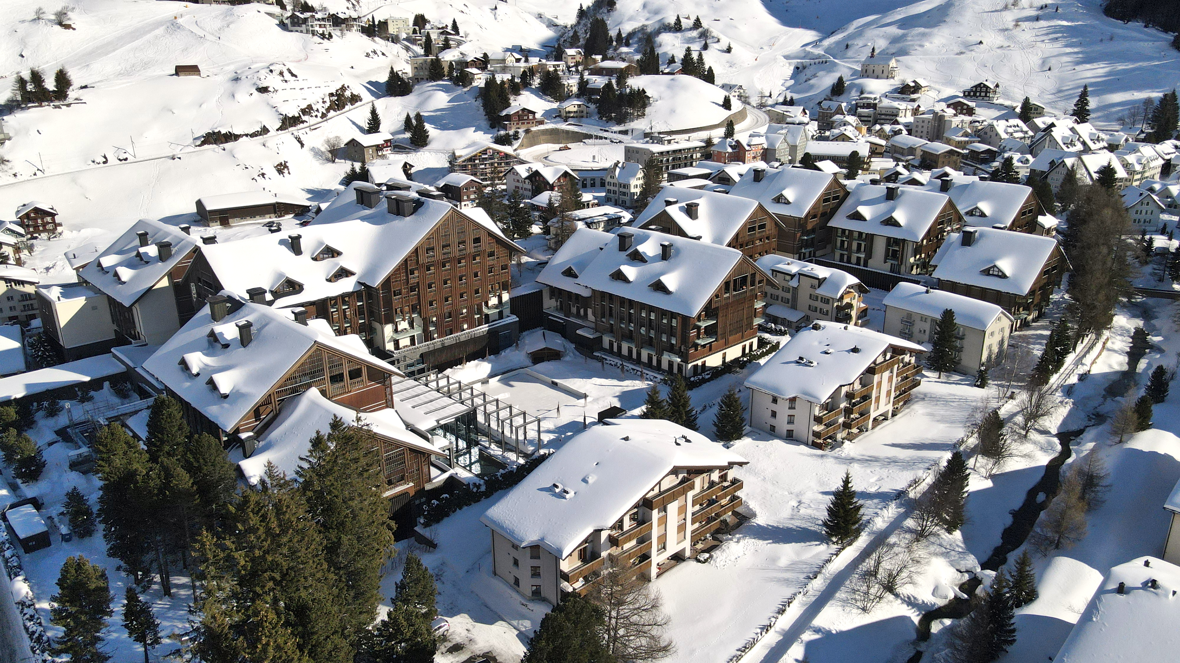 The Chedi Andermatt complete resort photographed from above covered with snow. 