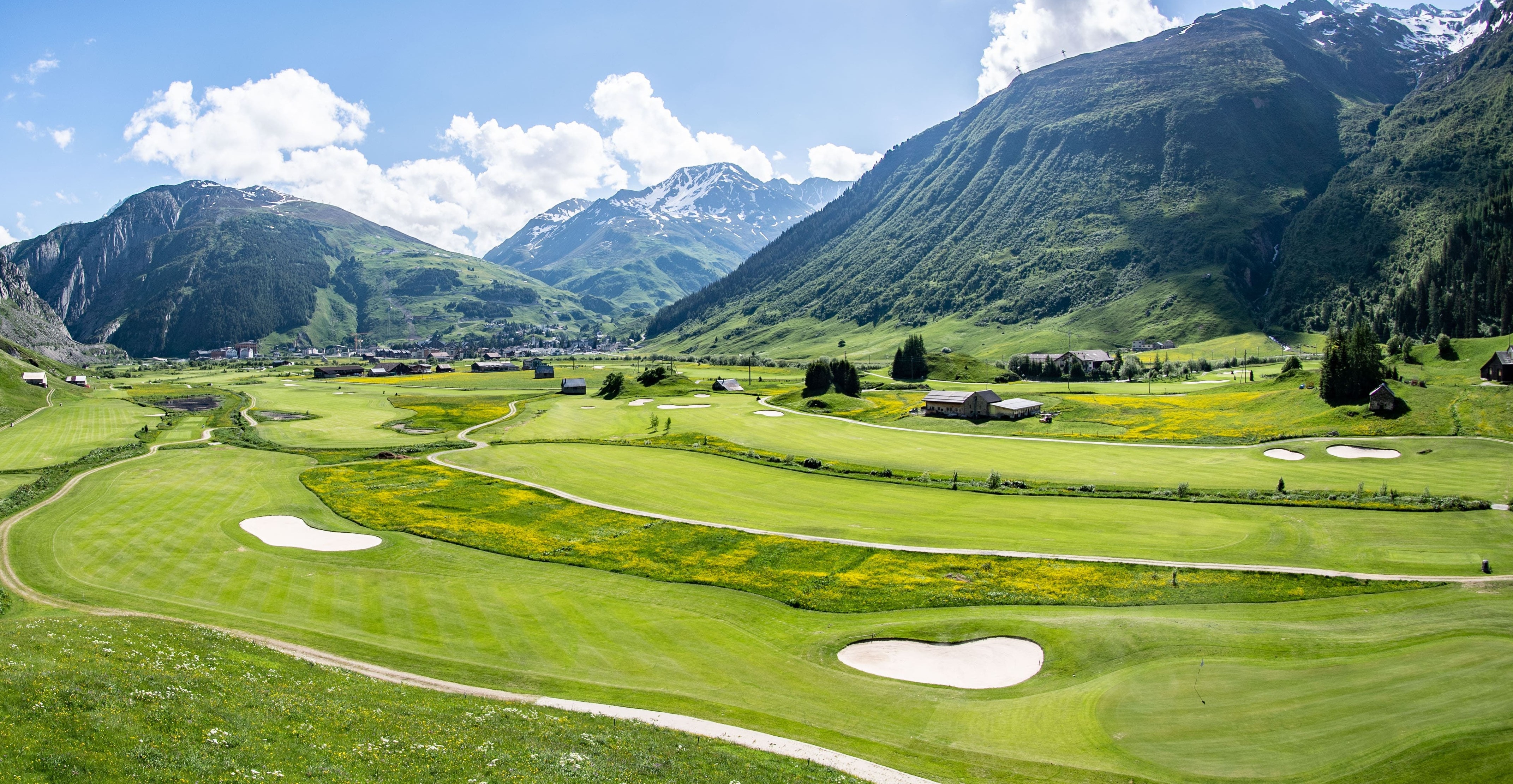 A Golf Course With Mountains In The Background