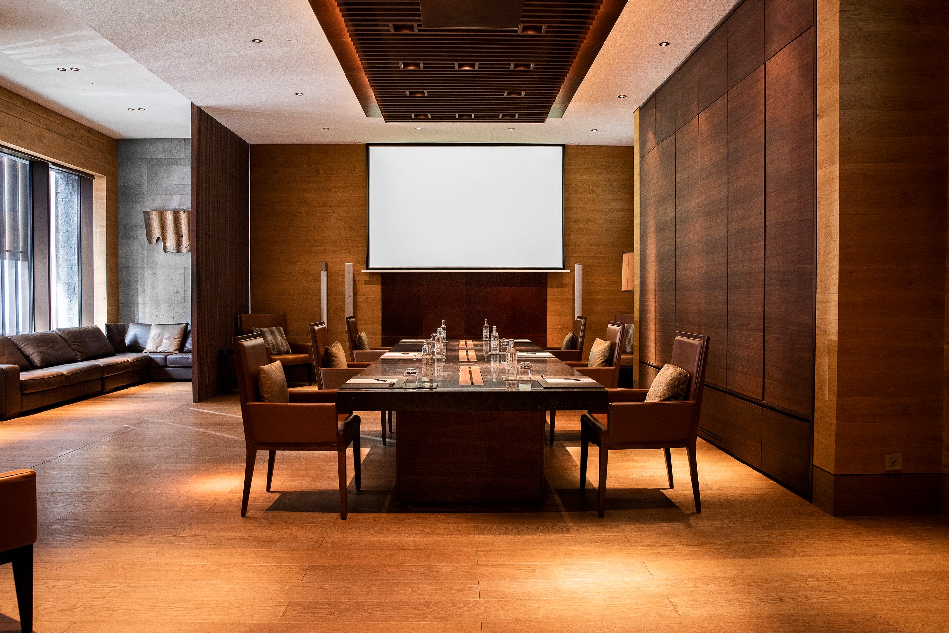 Meeting room at The Chedi Andermatt. Central the marble table on the left side a couch for a cozy break at the large windows.